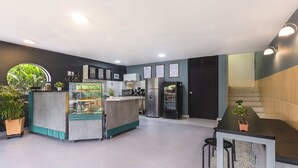 A modern kitchen with a central island, a refrigerator, and a coffee machine. - Living Hostal - Hostel (Medellín)
