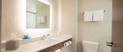 A bathroom with a white sink, a mirror, a toilet, and a towel rack.