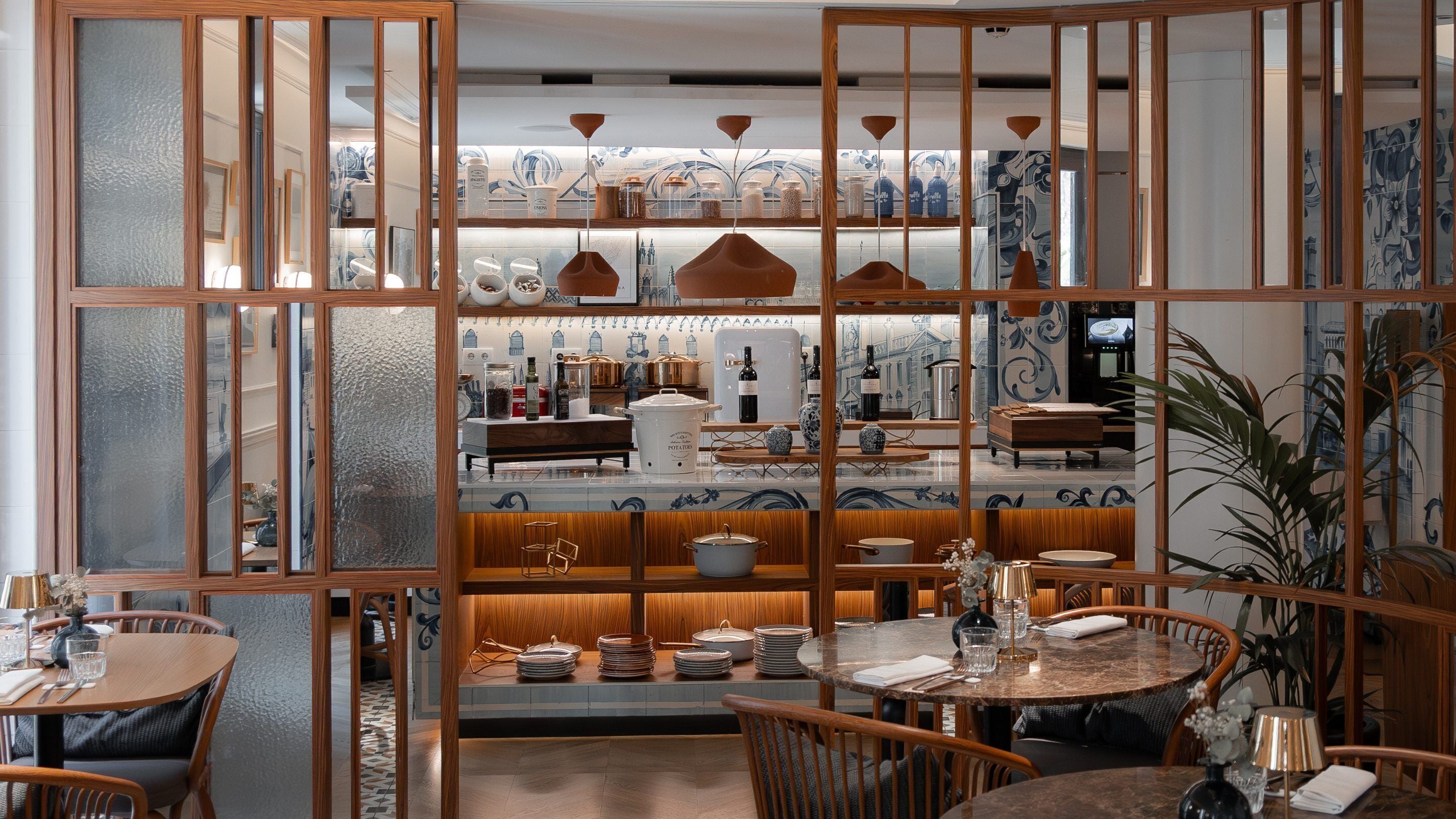 Un restaurant à l’intérieur de style japonais traditionnel, avec des cloisons en bois, un espace de sièges central et une variété de plats présentés sur des étagères.