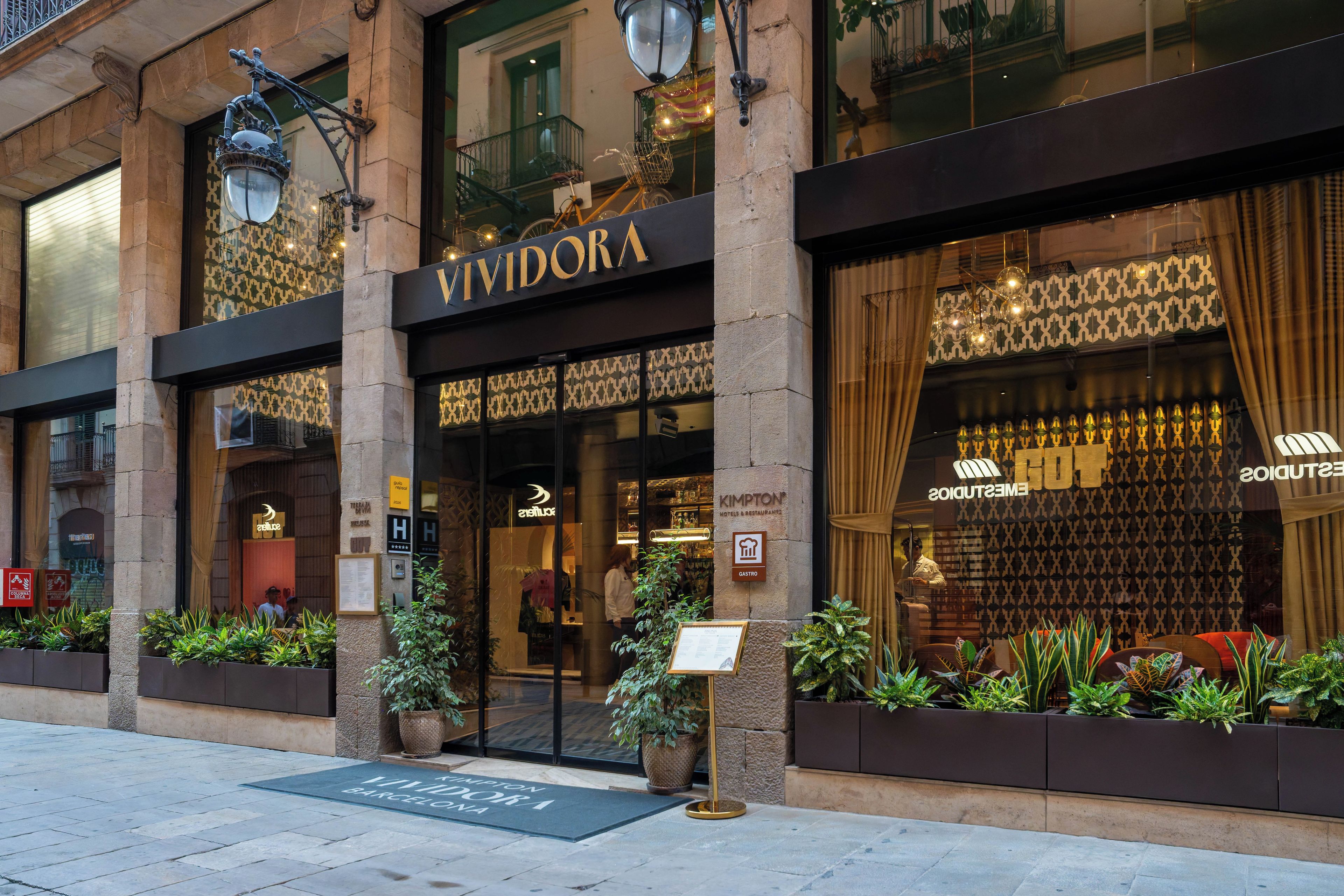 A hotel entrance with a sign reading 'VIVIDORA' and a 'Gastro' restaurant sign.