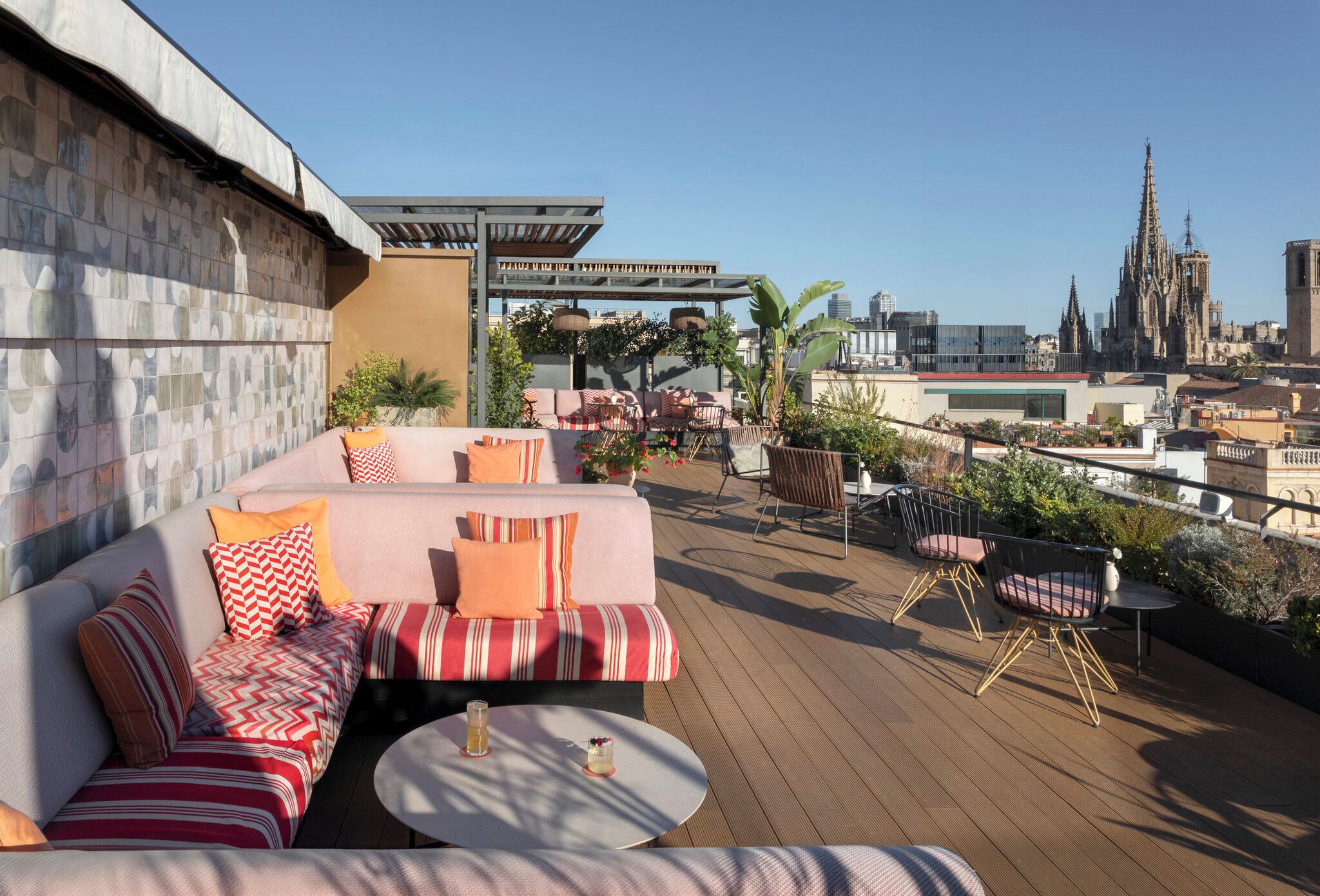 A rooftop terrace with a sofa set, a round table, and outdoor seating.