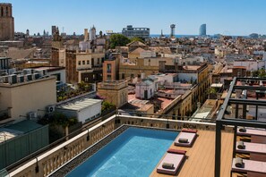 A rooftop pool with a view of the cityscape, including buildings and a clear sky. - Kimpton Vividora Hotel by IHG (Barcelona)