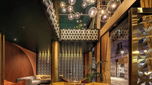 Una hall moderna con un divano, poltrone, un tavolino da caffè e illuminazione decorativa.