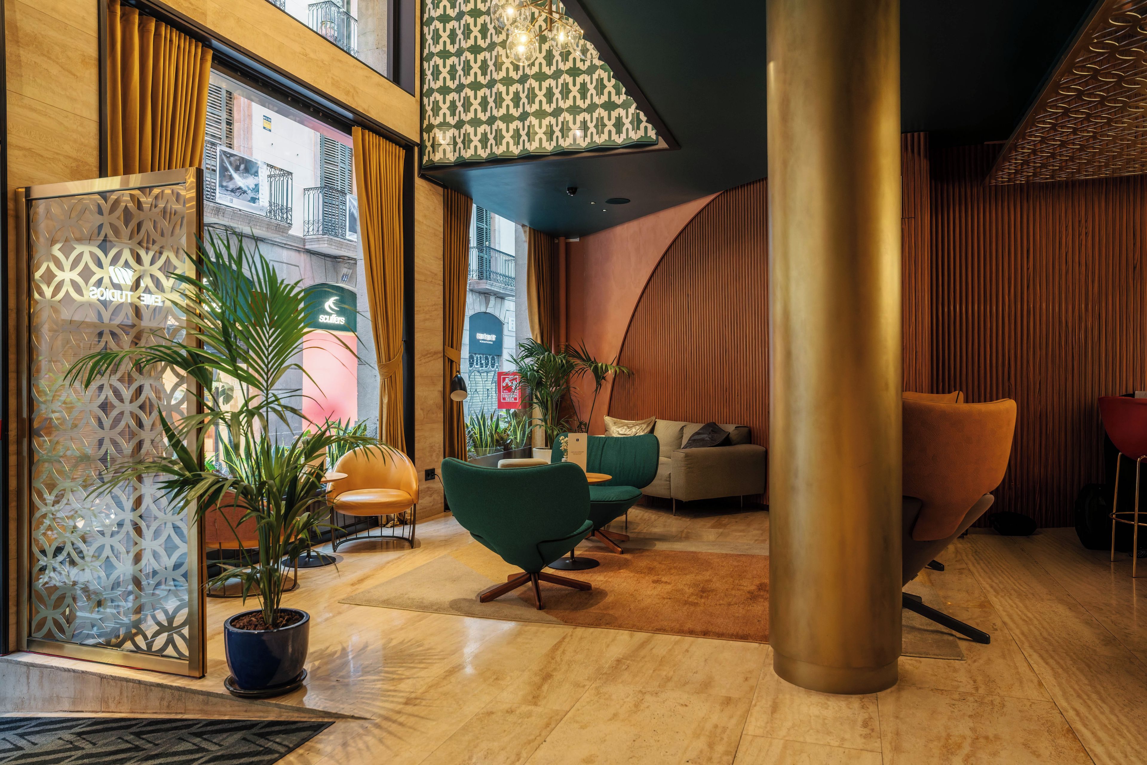 Un intérieur moderne avec un coin salon, des plantes en pot et une vue sur la rue.