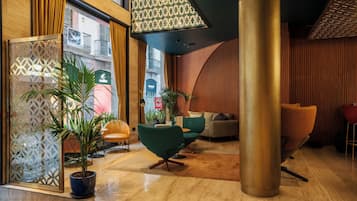 Un intérieur moderne avec un coin salon, des plantes en pot et une vue sur la rue.