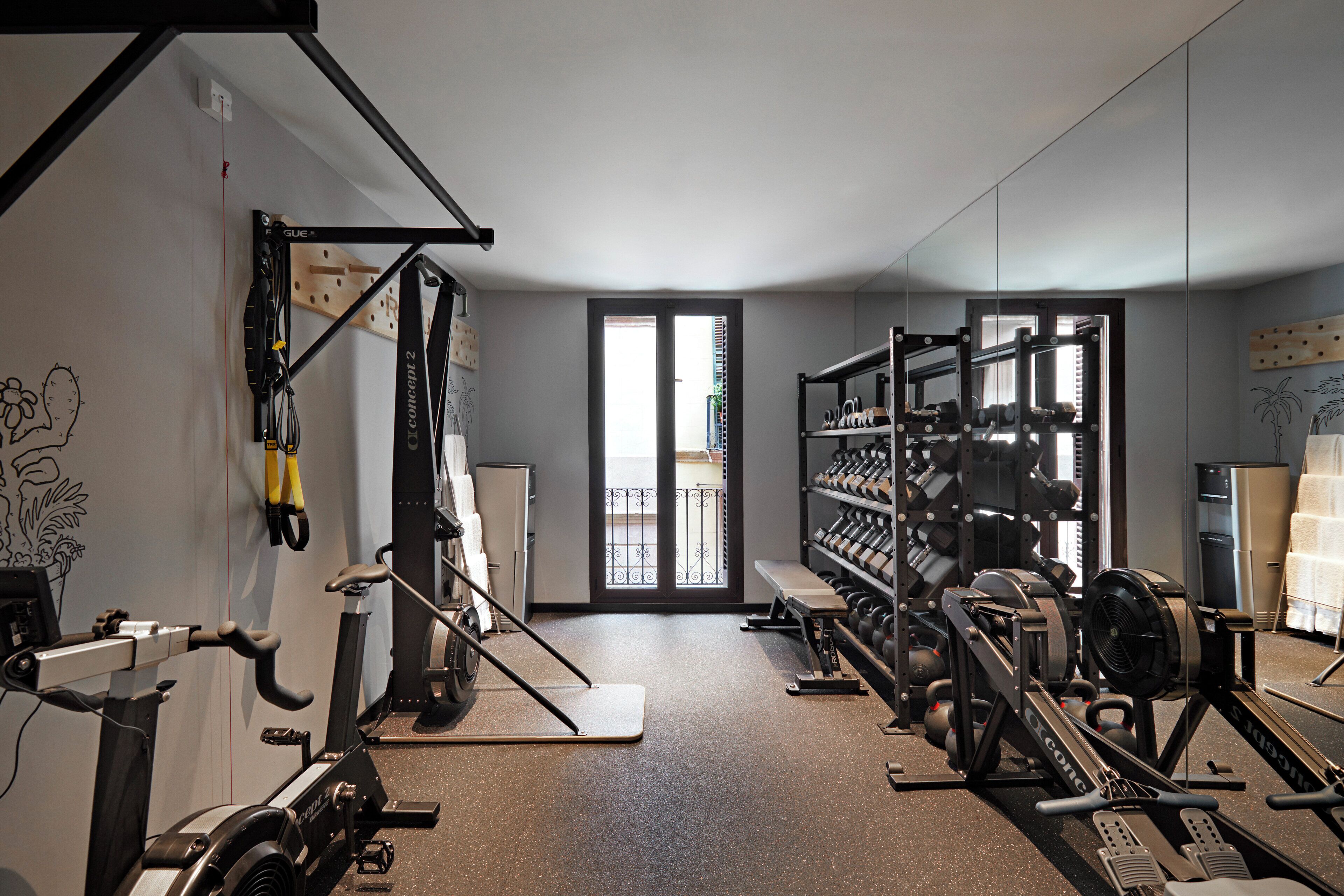 A gym with exercise equipment, a water dispenser, and a bench.