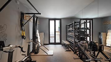 A gym with exercise equipment, a water dispenser, and a bench.