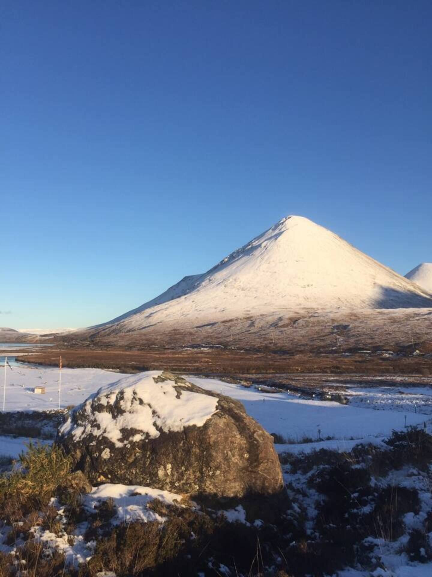 Una montaña cubierta de nieve con cielo despejado.