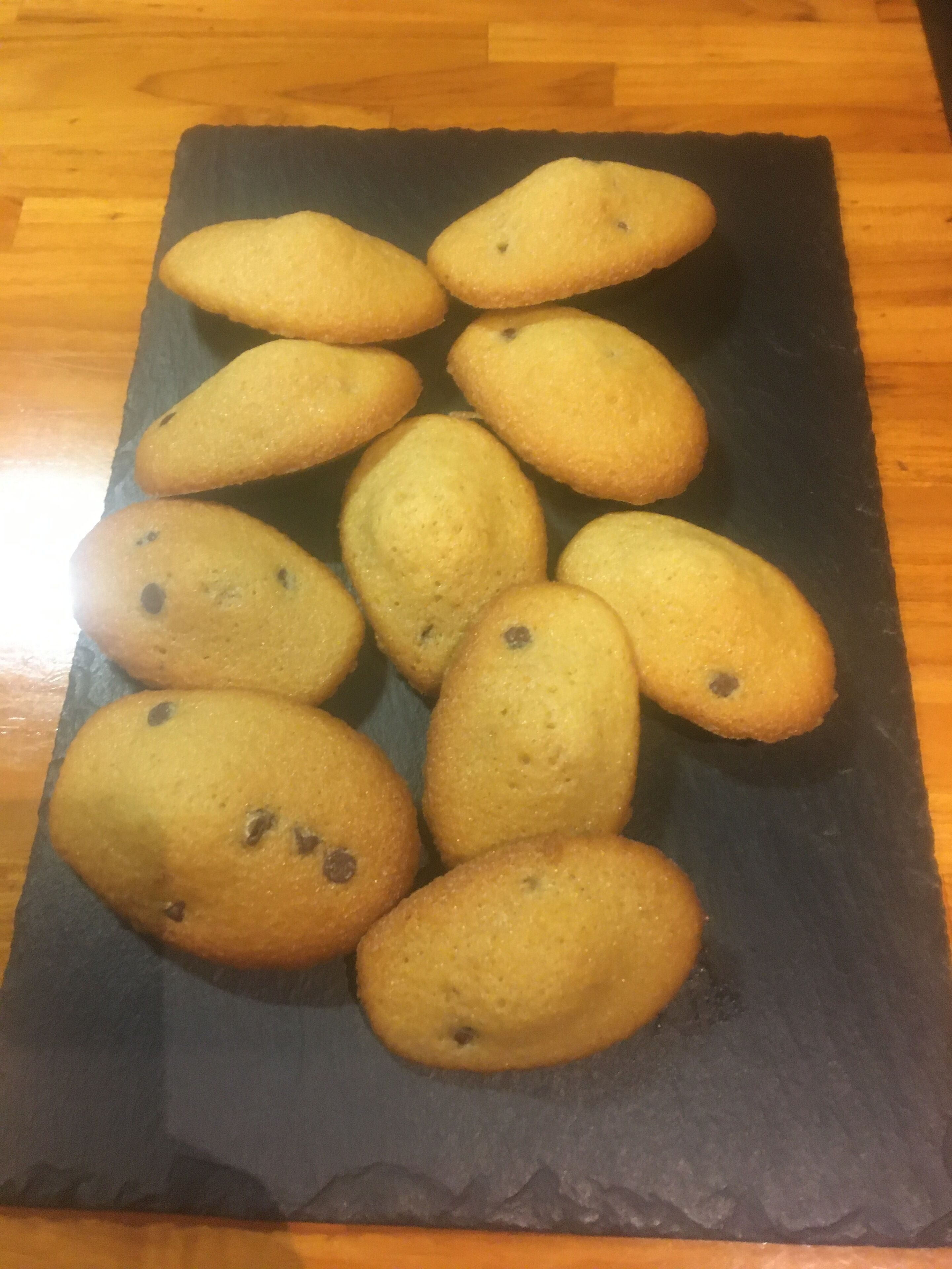 A slate serving board with several cookies on it.