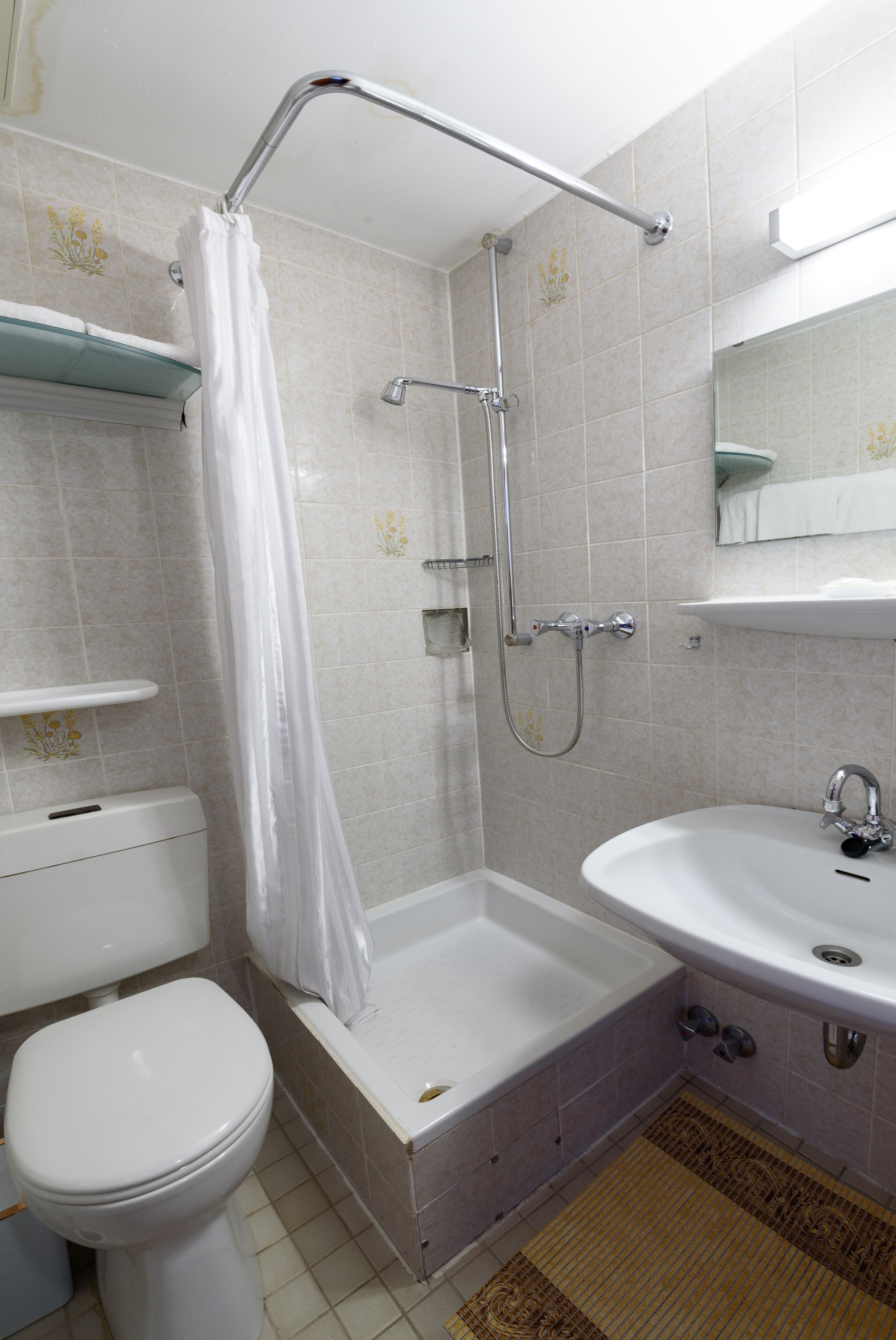 Een badkamer met toilet, badkuip, douche en wastafel.