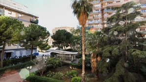 A residential area with apartment buildings, a parking lot, and a small garden area with trees and shrubs. - A Casa di Frà B&B (Palermo)