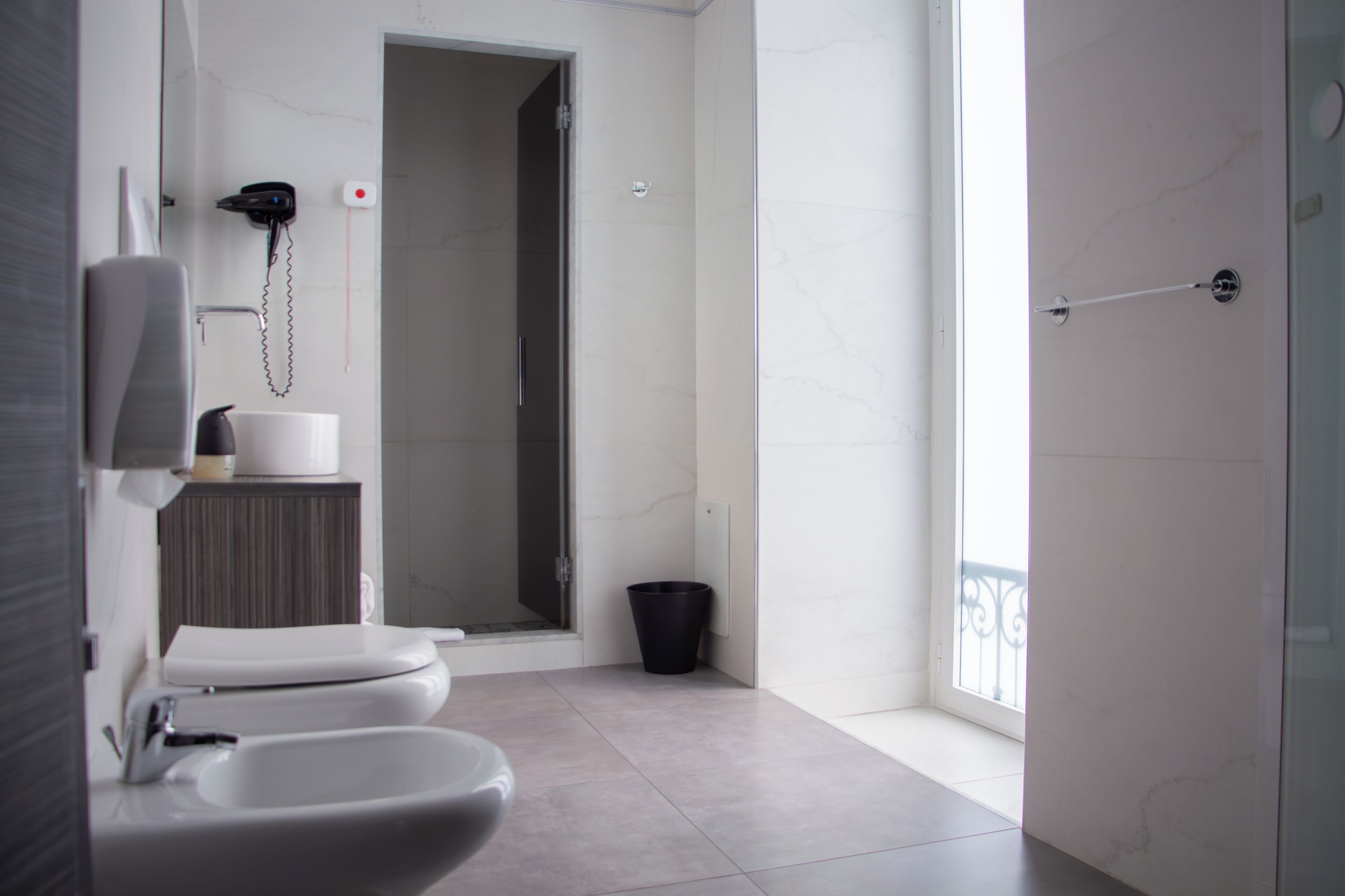 A modern bathroom with a toilet, bidet, and a shower area.
