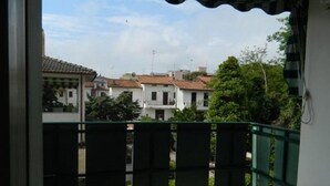 A balcony with a view of residential buildings and greenery.