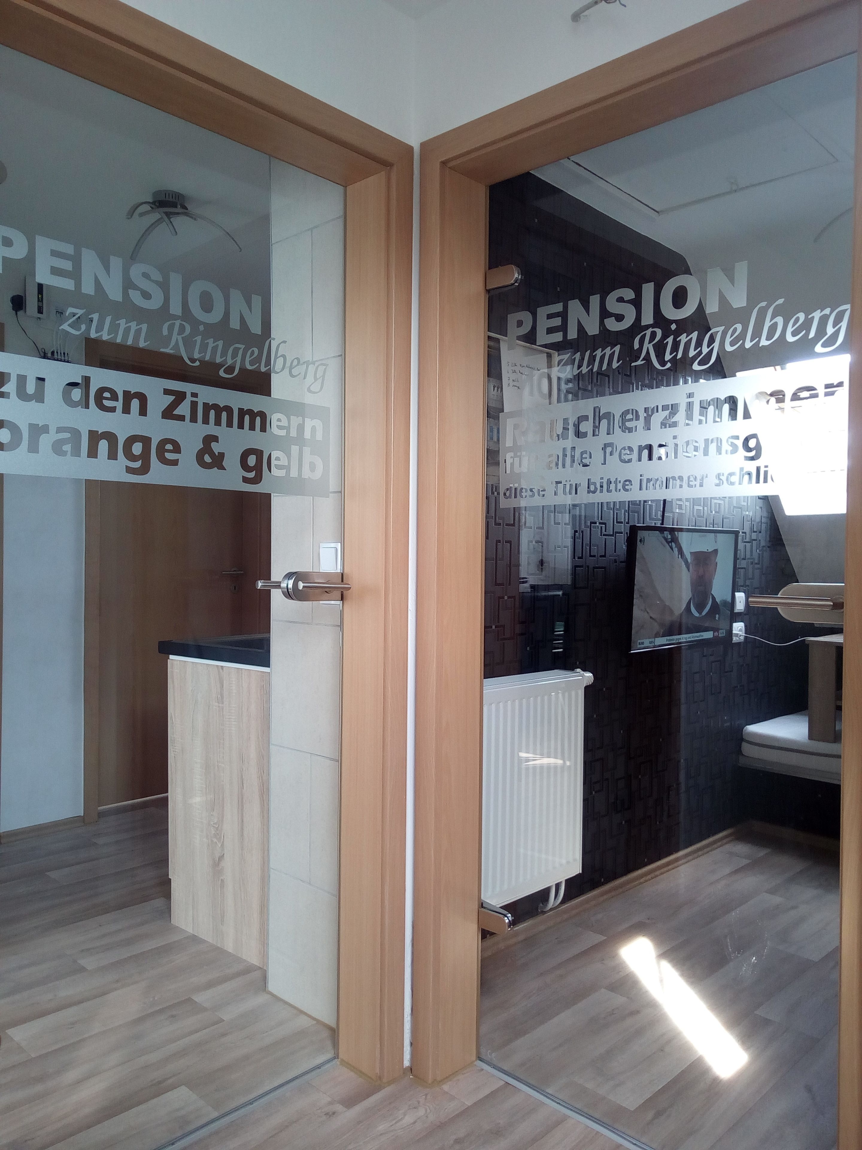 A modern office space with a wooden door, a black countertop, and a large window with a view of a building.