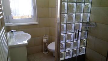 Ein kleines Badezimmer mit Toilette, Waschbecken und Fenster.