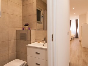 A modern bathroom with a toilet, sink, and shower.