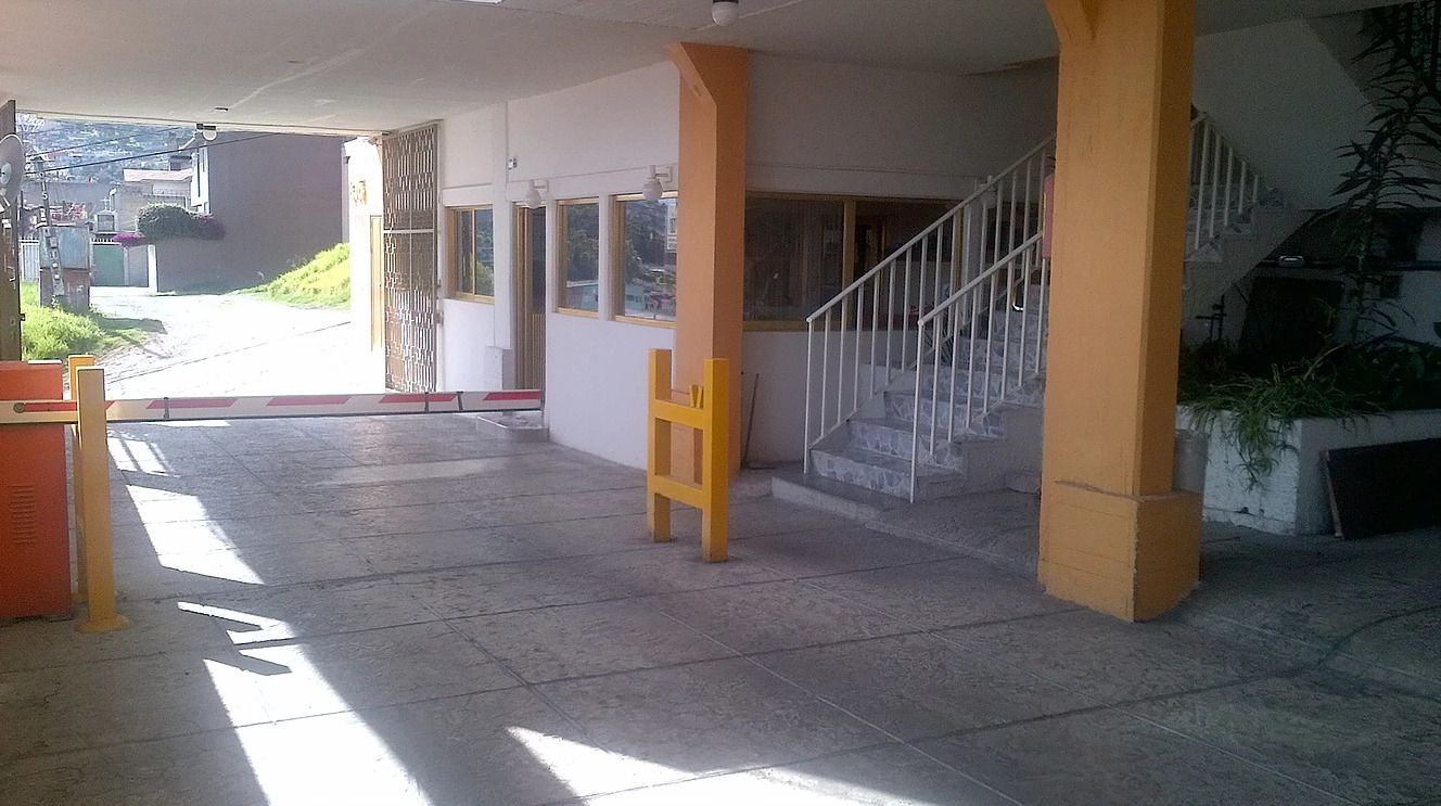 A spacious indoor area with a tiled floor, a staircase, and a yellow chair.