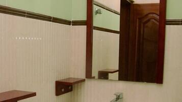 A bathroom with a white sink, a mirror, and a wooden vanity.