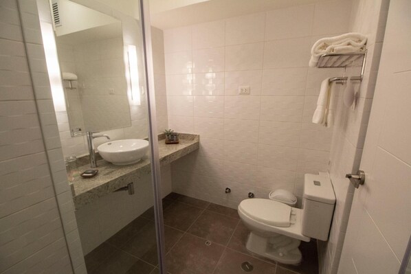 A bathroom with a sink, mirror, toilet, and towel rack. - Tierra Viva Piura (Piura)