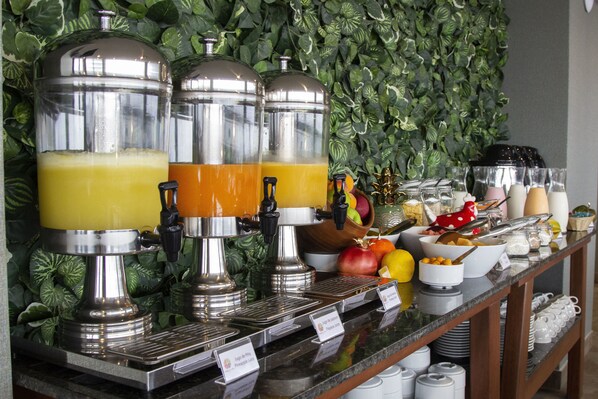 A buffet with multiple juice dispensers, a variety of fruits, and a selection of bowls and cups. - Tierra Viva Piura (Piura)