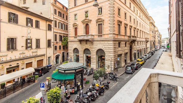 A historic building with a prominent entrance and a green awning. - RSH Ara Pacis Enchanting Apartment (Rome)