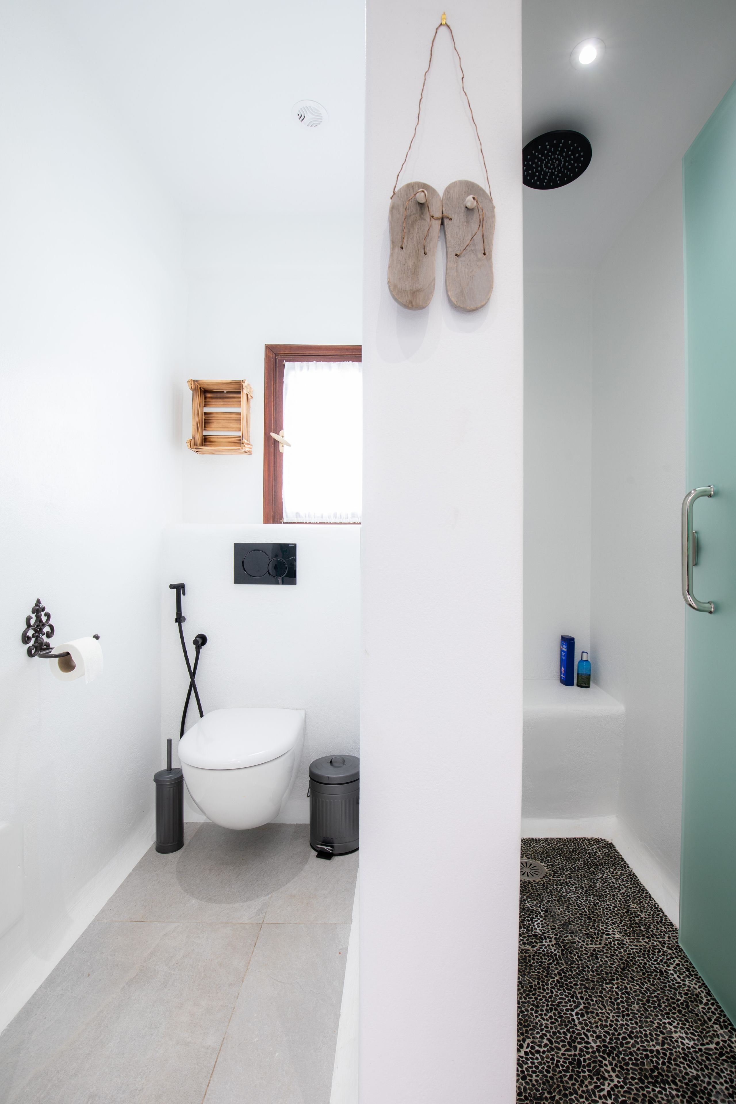 A modern bathroom with a toilet, bidet, and shower area.