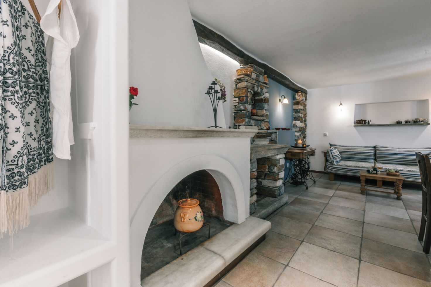 Una sala de estar acogedora con chimenea de piedra, un sofá y una mesa de centro.