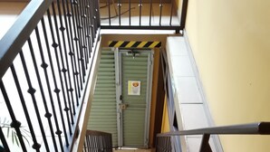 A staircase with metal railings, stone steps, and a yellow wall. - Hospedaje Yaldai (Turrialba)