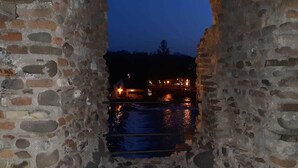 Un arc en pierre mène à une étendue d’eau dont la surface est illuminée par des jeux de lumière.