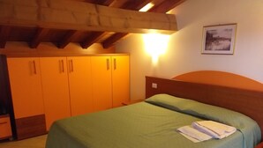 Une pièce comprenant un lit, une armoire et un tableau encadré accroché au mur.