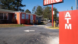 A red building with a sign that reads "HOTEL" and an ATM on the right. - Hotel O Atlanta Airport Jonesboro/Morrow I-75 (Jonesboro)