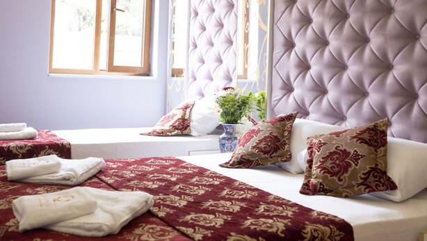 A bedroom with a tufted headboard, a large window, and a bed with red and white bedding. - The Zanadu İstanbul (Istanbul)