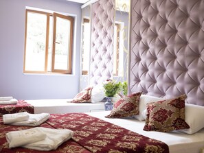 A bedroom with a tufted headboard, a large window, and a bed with red and white bedding. - The Zanadu İstanbul (Istanbul)
