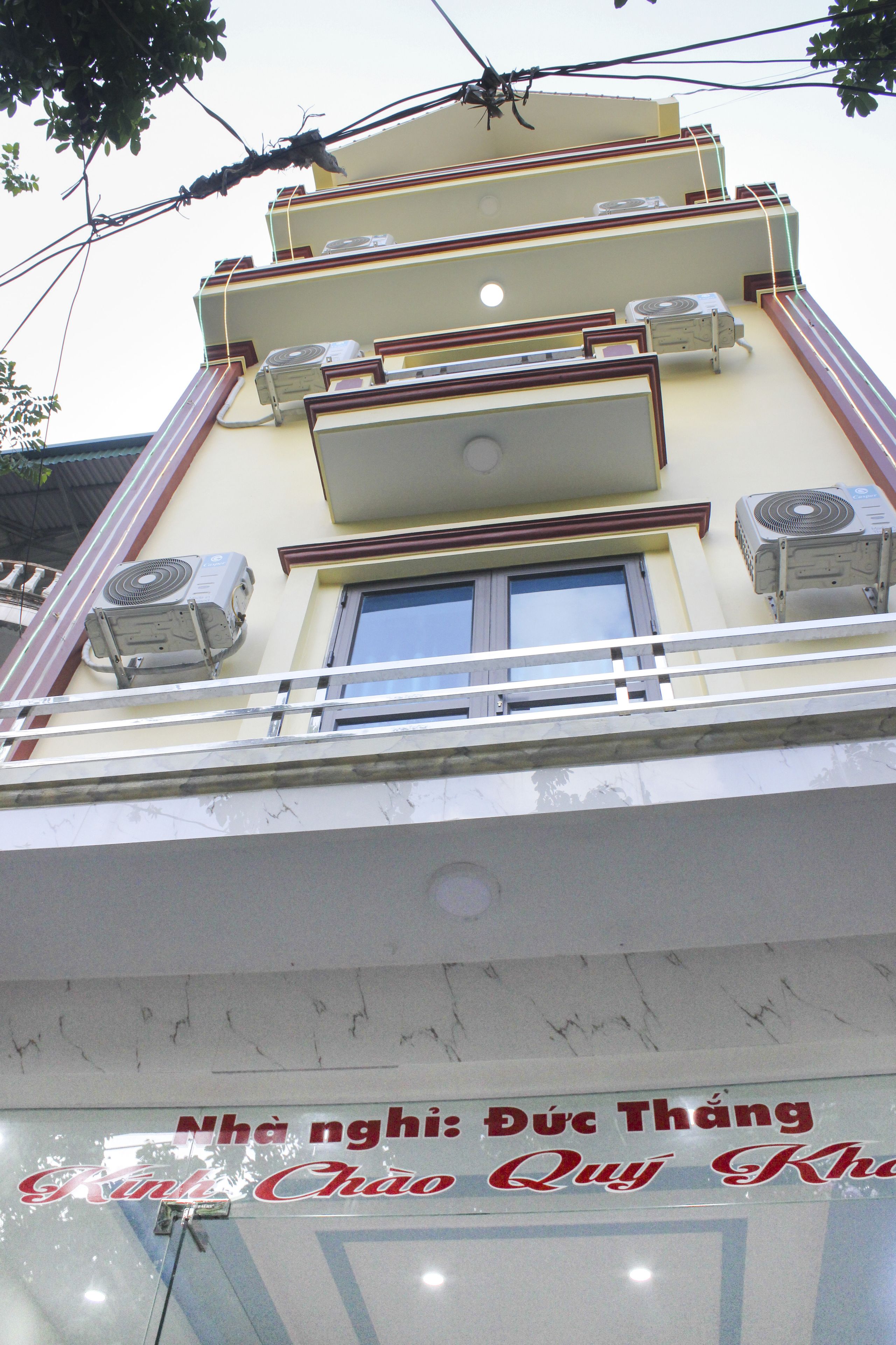 A building with multiple air conditioning units, a balcony, and a window.