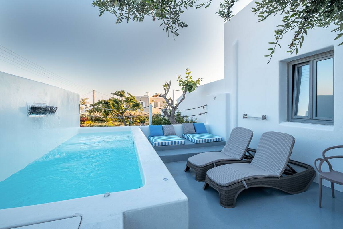 Un espace piscine extérieur moderne, doté de chaises longues et d’un jacuzzi.