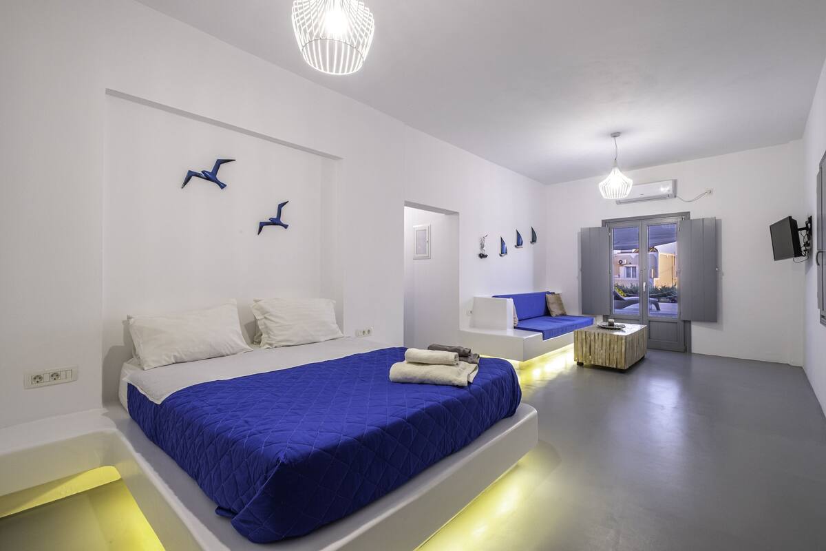 Une chambre d’hôtel moderne avec deux lits, un coin salon et une vue sur la ville.