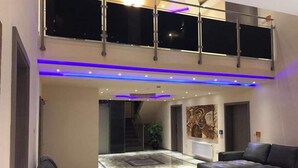 A spacious living area with a high ceiling, a mezzanine level, and a large window. - Hotel Babylon (Ringsheim)