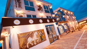 A building with a facade decorated with murals and lights, featuring a sign that reads "BABY LION." - Hotel Babylon (Ringsheim)