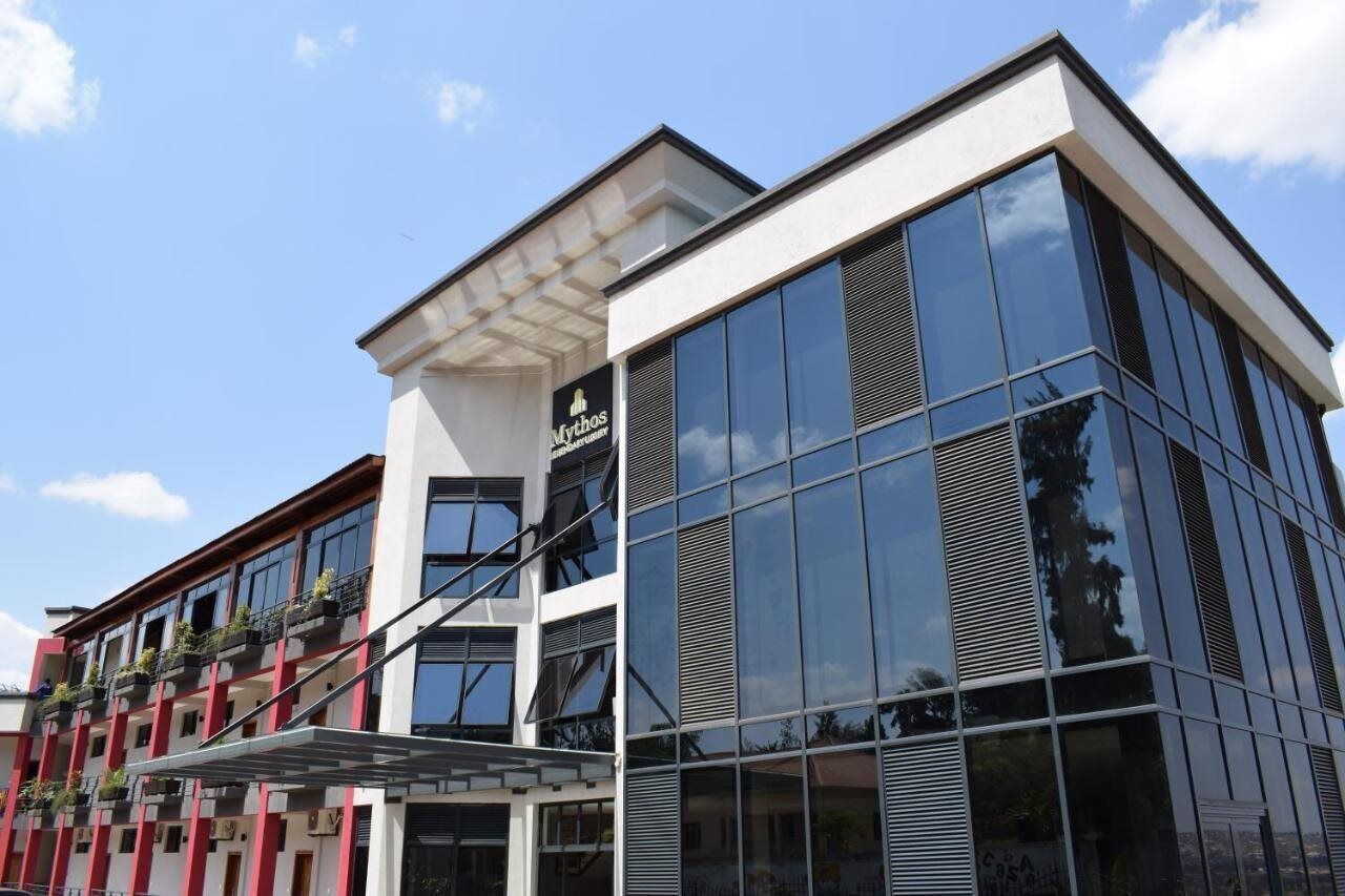 A modern building with large glass windows and a sign for 'Mythos'.