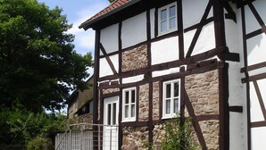 A traditional half-timbered house with stone walls and a red-tiled roof. - Ferienhaus am Solling (Dassel)