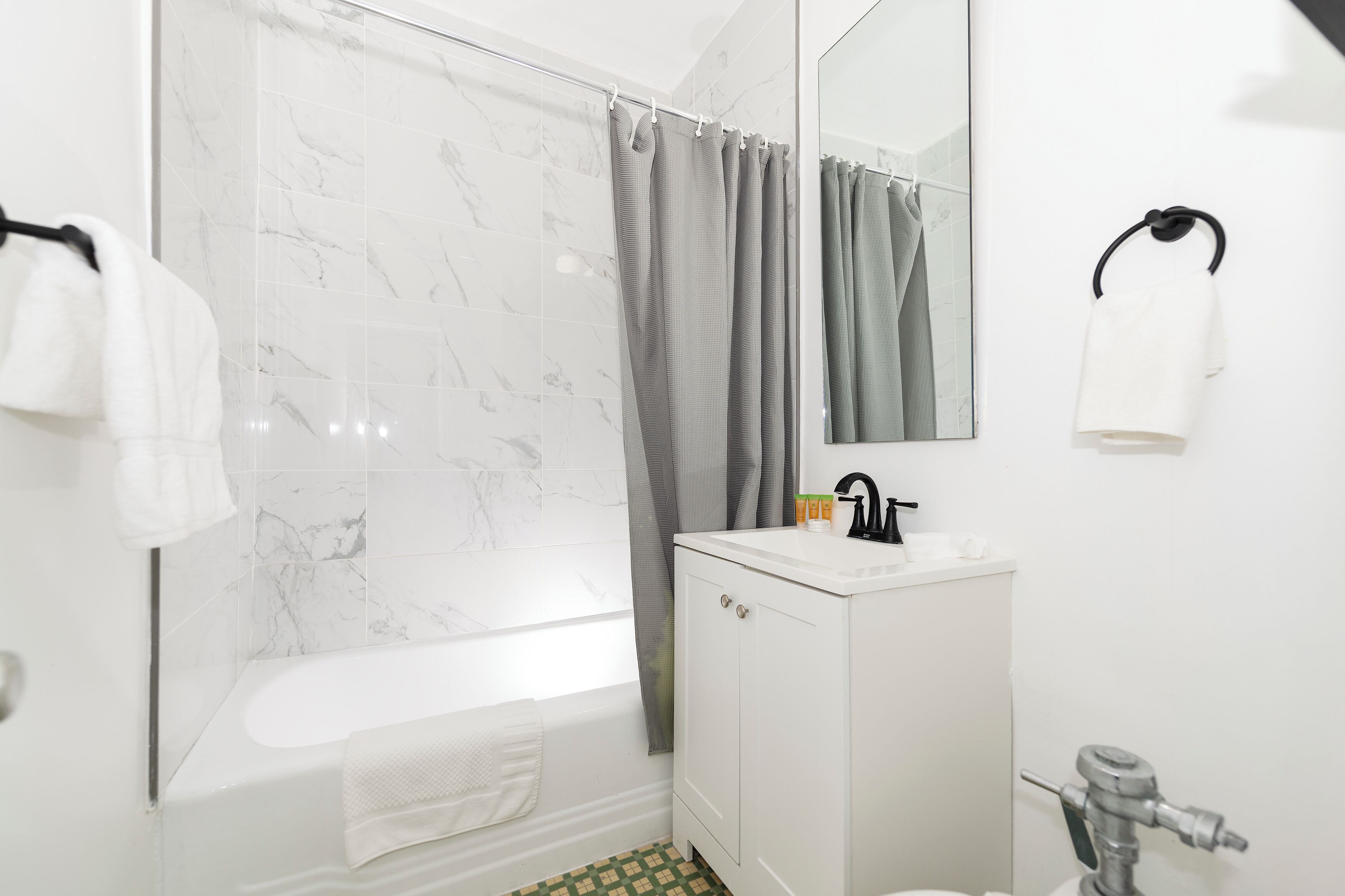 A modern bathroom with a bathtub, a shower, a sink, and a toilet.