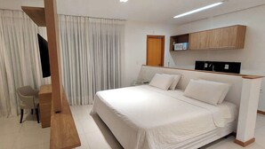 Une chambre d’hôtel équipée d’un lit, d’un bureau, d’une chaise, d’une télévision et d’un four à micro-ondes.