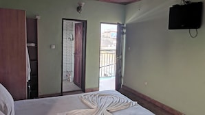 A room with a bed, a wardrobe, a mirror, a door, and a television. - Hôtel 2S (Douala)