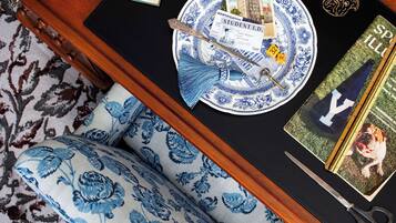 A table with a book, a plate with a blue floral pattern, a pair of scissors, and a book titled 'SPILL'.