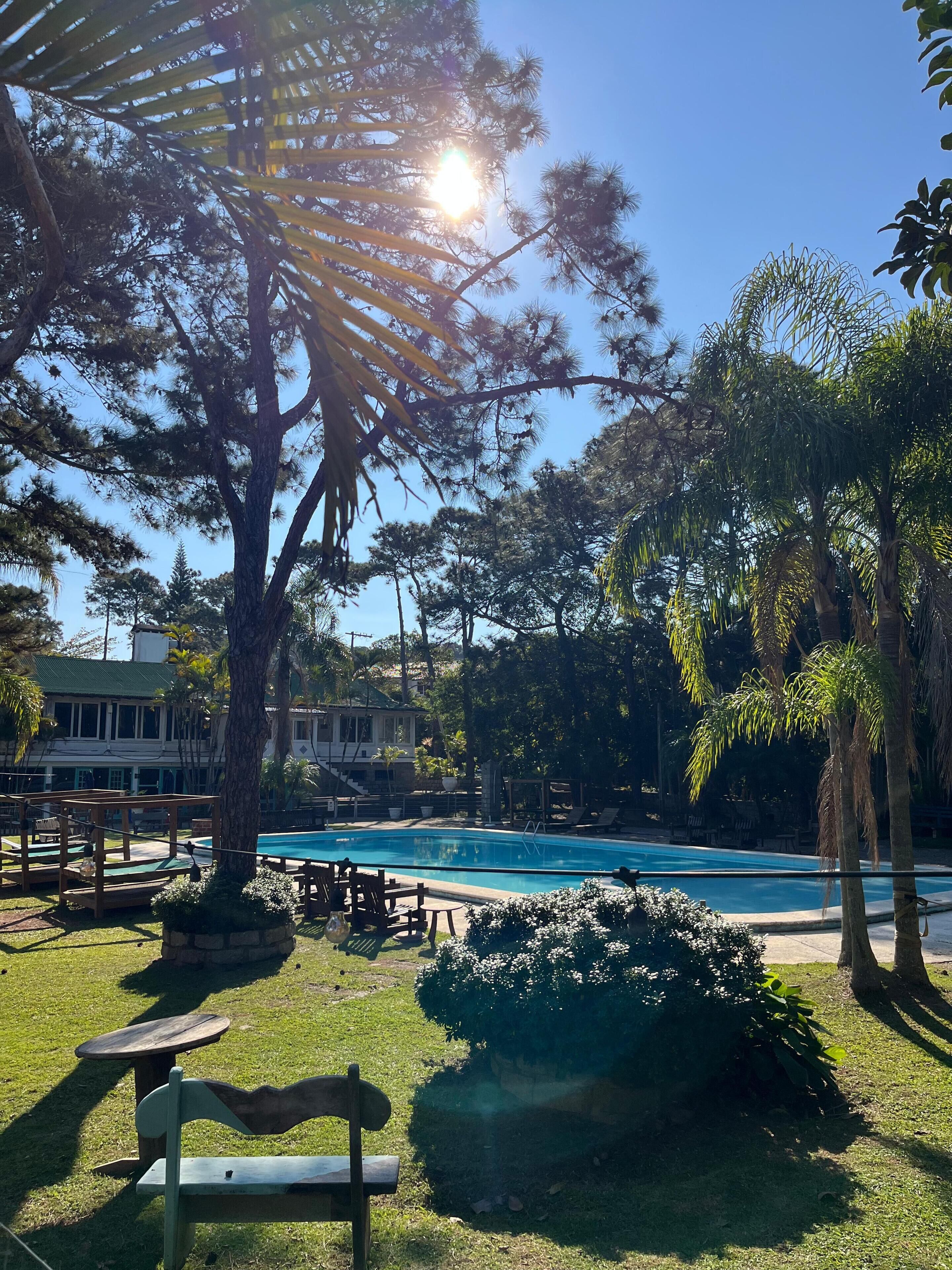 Una piscina al aire libre de temporada, sombrillas, tumbonas