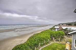 Guest house with ocean views, overlooking a well-maintained lawn and the beach.