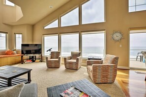 Relax in this serene living space with ocean views, comfortable seating, and a flat-screen TV.