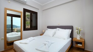 Een hotelkamer met een bed, nachtkastje, spiegel en raam.