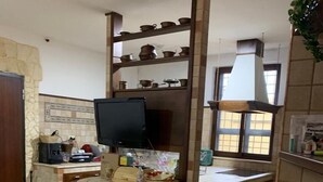A kitchen with a wooden island, a television, and a window with a view. - Villa Carmen (Mondragone)