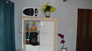 A kitchenette with a microwave, cereal box, coffee maker, and a potted plant. - Villa Carmen (Mondragone)